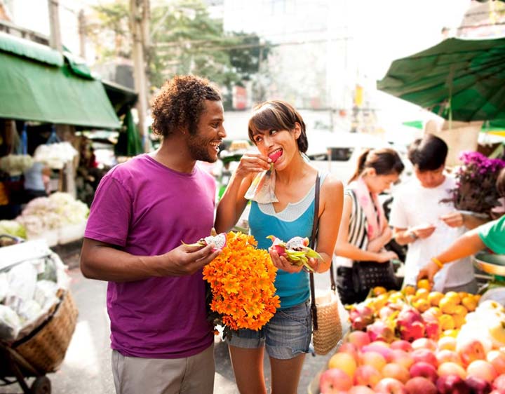 Man and women walking and eating fruit showing healthy cortisol levels.