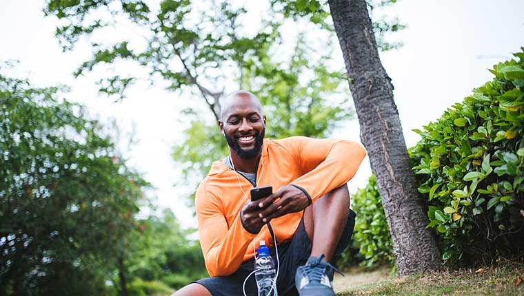 Individual smiling while exercising and drinking water.