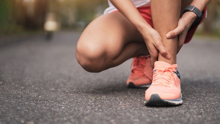 Jogger massages own ankle.